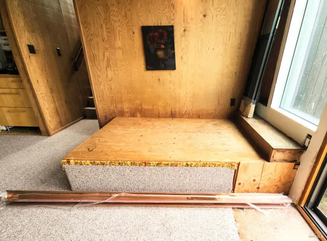 a bed sitting in a bathroom next to a window