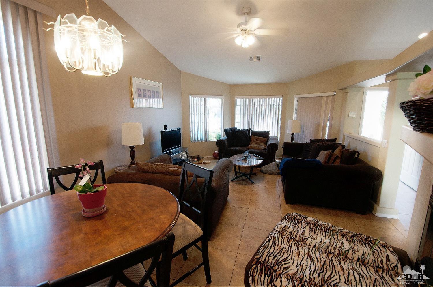 68874 Risueno Road Cathedral City, CA 92234 - Photo 2 of 8 a living room with furniture a large window and wooden floor