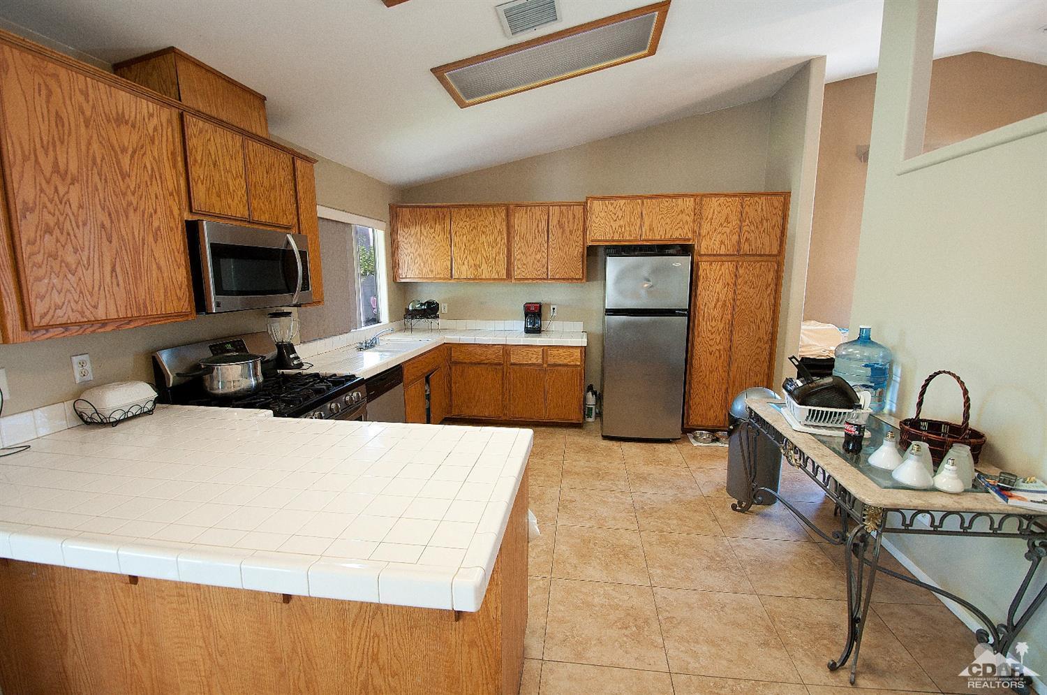 68874 Risueno Road Cathedral City, CA 92234 - Photo 4 of 8 a kitchen with a sink a stove and a refrigerator