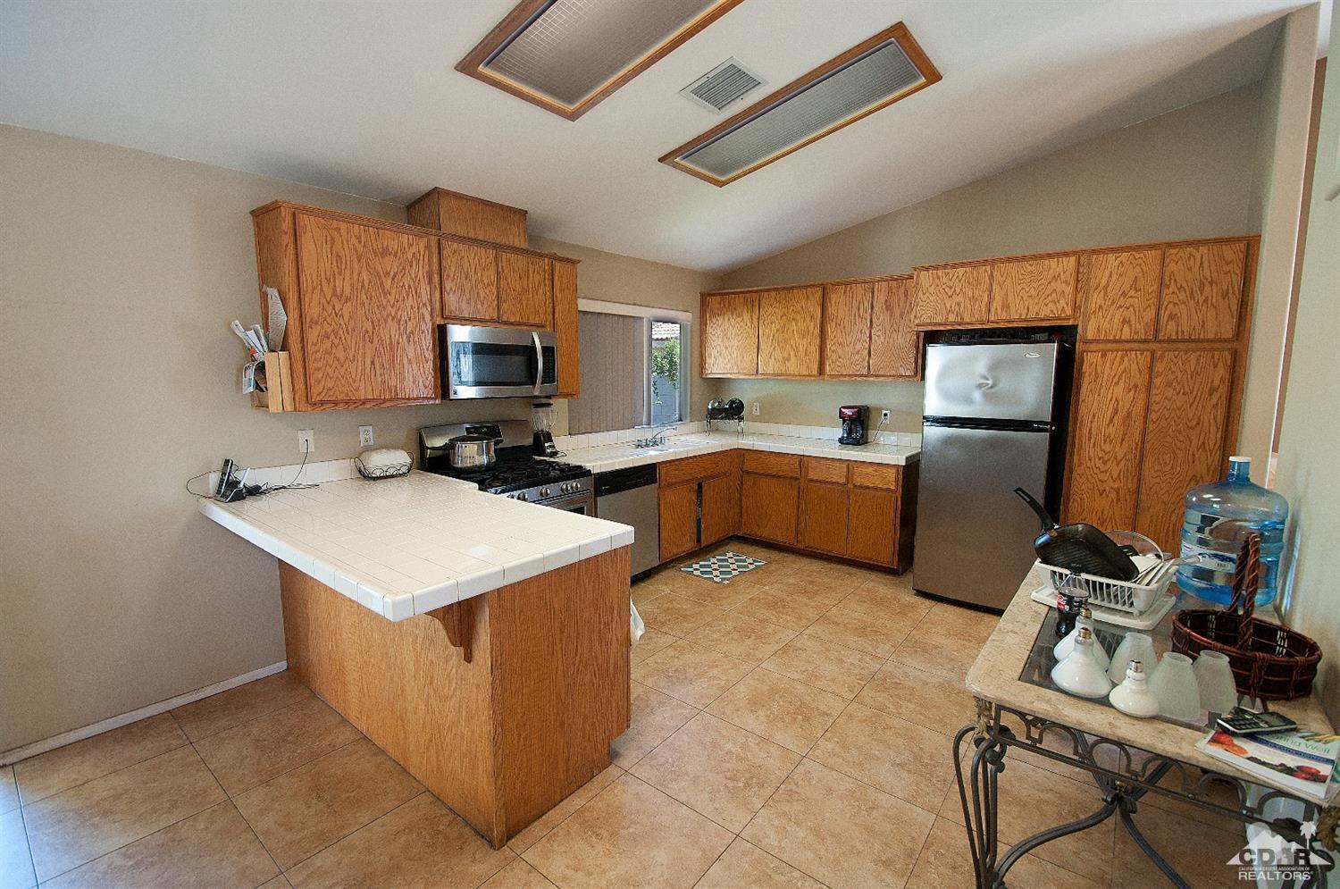 68874 Risueno Road Cathedral City, CA 92234 - Photo 5 of 8 a kitchen with a sink a counter top space cabinets stainless steel appliances and a window