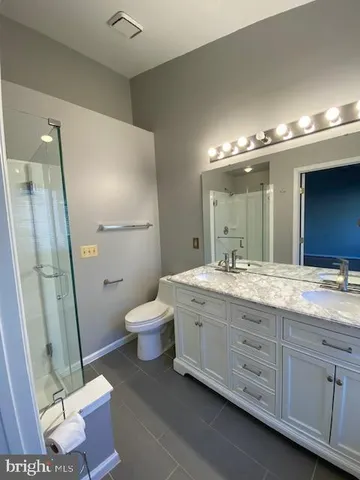 a bathroom with a double vanity sink a toilet and a mirror