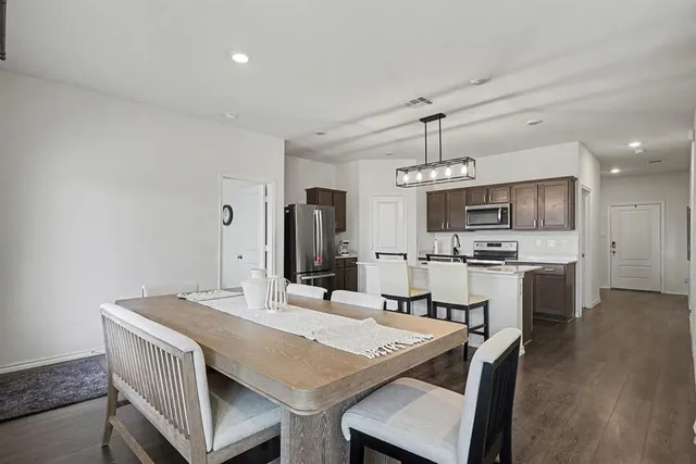 a kitchen with a sink a stove cabinets and wooden floor
