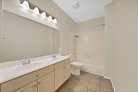 a bathroom with a double vanity sink a toilet and a mirror