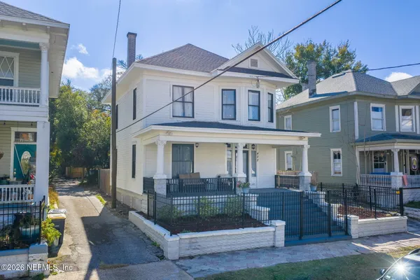 a front view of a house with barbeque and outdoor seating