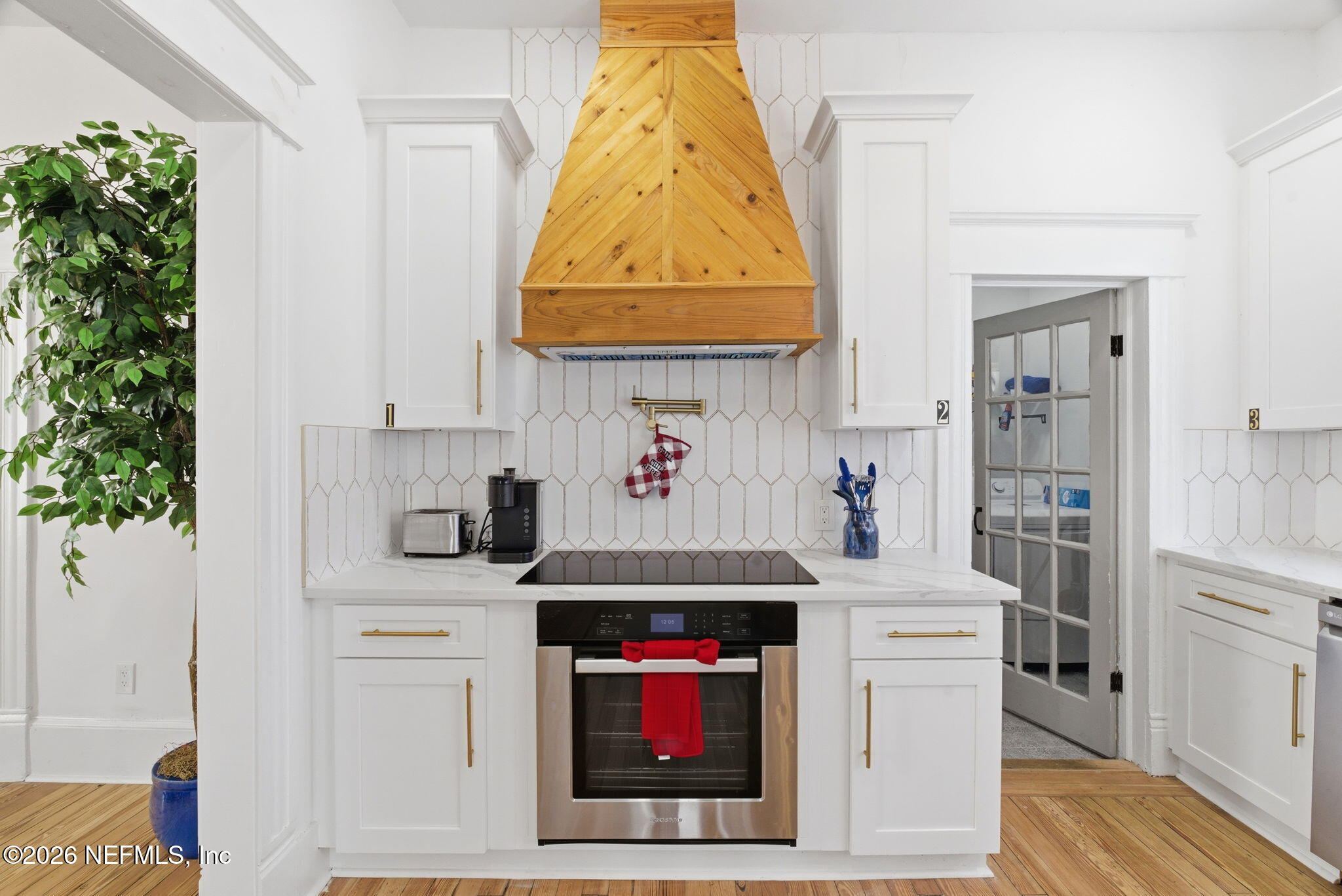 422 7th Street West Jacksonville, FL 32206 - Photo 19 of 71 a kitchen with stainless steel appliances kitchen island granite countertop a refrigerator a stove a sink and white cabinets with wooden floor