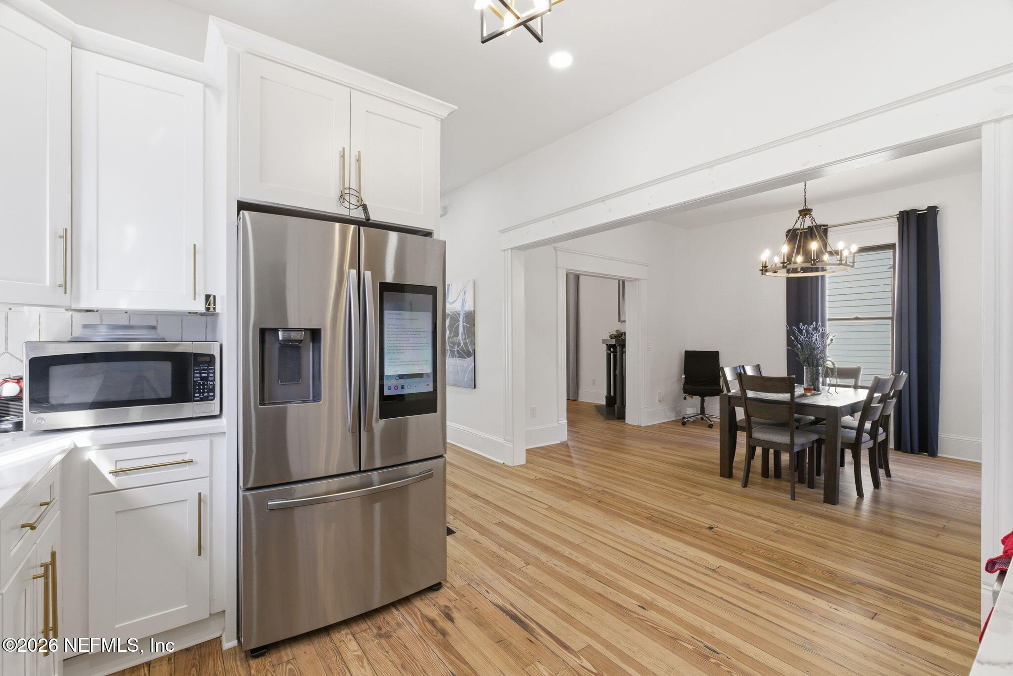 422 7th Street West Jacksonville, FL 32206 - Photo 21 of 71 a kitchen with stainless steel appliances a refrigerator stove a dining table and chairs with wooden floor