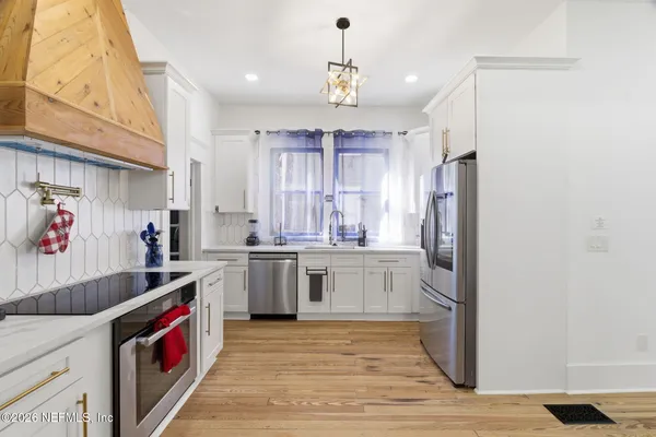a view of a dining room with furniture a chandelier and wooden floor