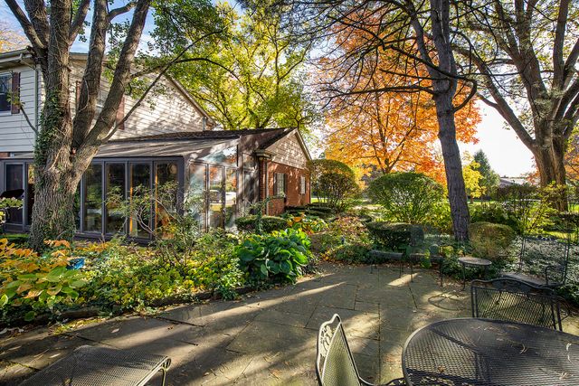 a backyard of a house with a garden and outdoor seating