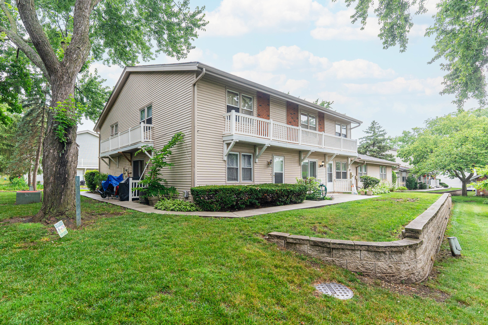 327 Georgetown Court, Unit B Bloomingdale, IL 60108 - Photo 24 of 25 a view of a white house next to a yard with big trees