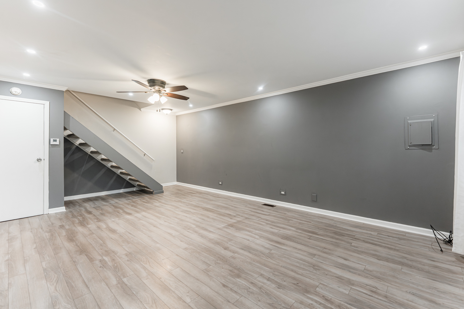 327 Georgetown Court, Unit B Bloomingdale, IL 60108 - Photo 3 of 25 an empty room with wooden floor fan and windows