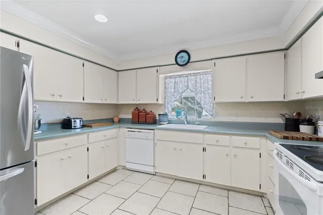 a kitchen with white cabinets and white appliances
