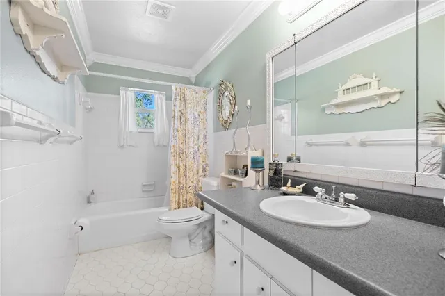 a bathroom with a granite countertop sink a toilet a mirror and shower