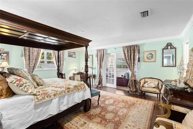 a bedroom with a bed couch and a large window