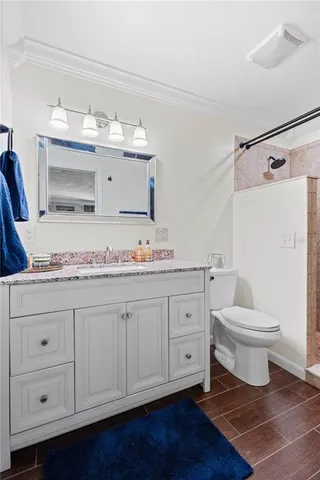 a bathroom with a toilet sink double vanity and mirror