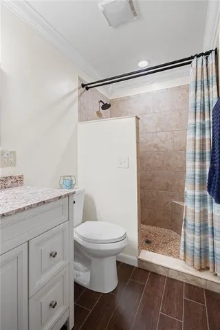 a bathroom with a granite countertop sink toilet and shower
