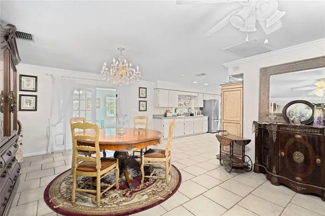 a dining room with chandelier and wooden floor
