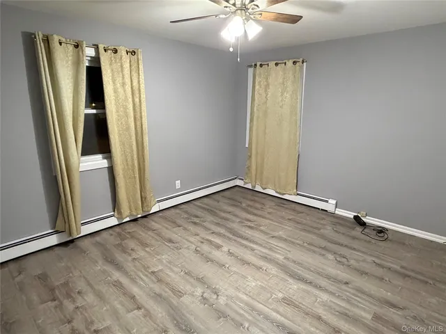 an empty room with wooden floor and entrance