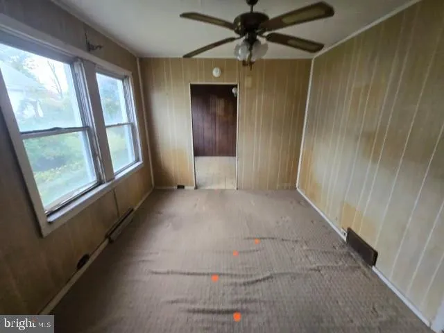 a view of hallway with window and a ceiling fan