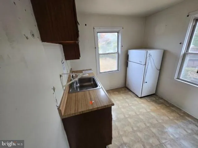 a kitchen with a sink a refrigerator and window