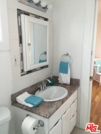 a bathroom with a granite countertop sink and a mirror