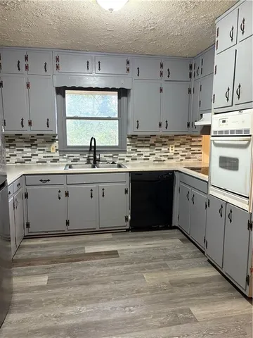 a kitchen with stainless steel appliances granite countertop a stove and white cabinets