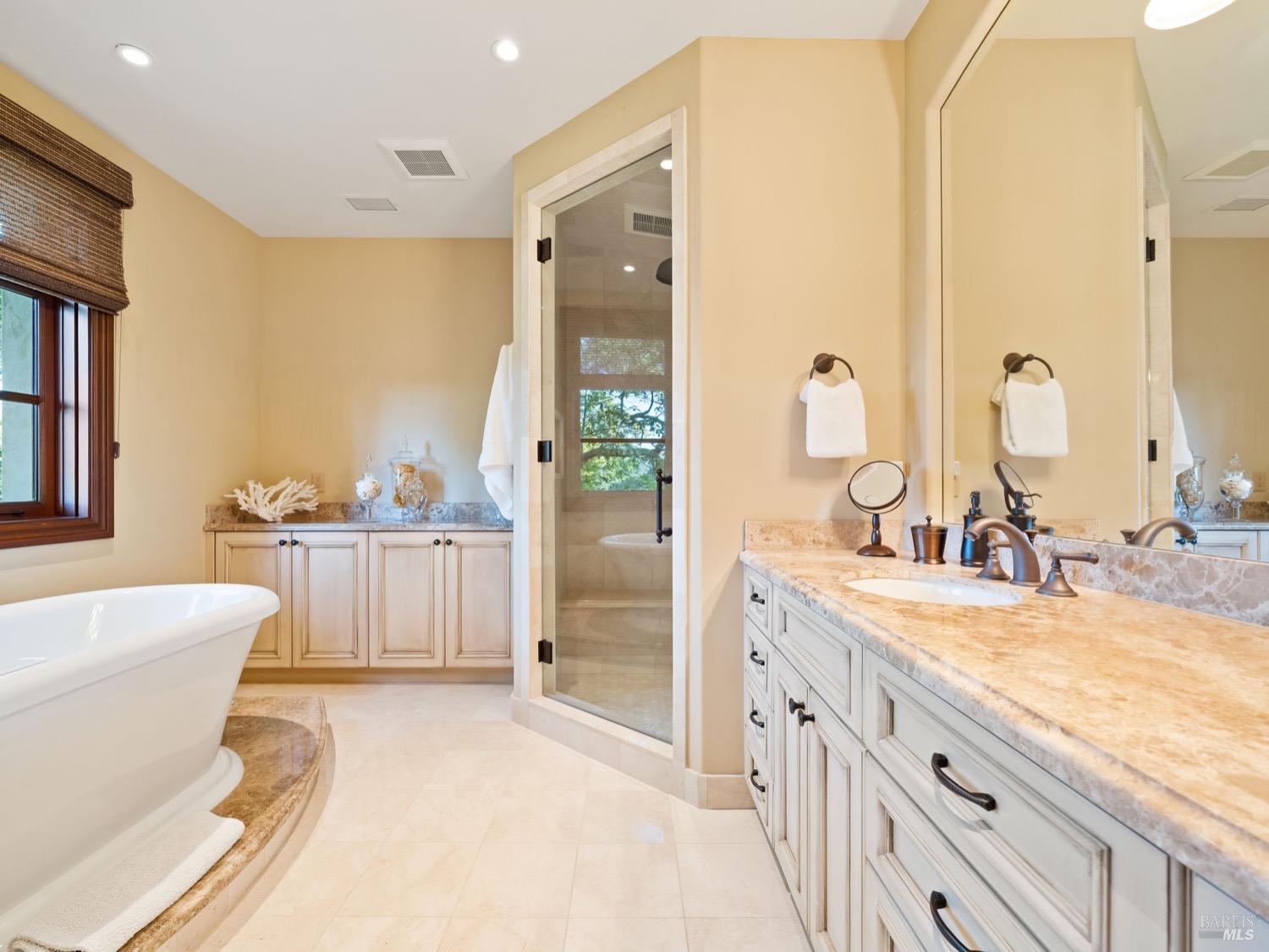 6444 Cottage Ridge Road Santa Rosa, CA 95403 - Photo 58 of 95 a spacious bathroom with a double vanity sink a mirror and a bathtub