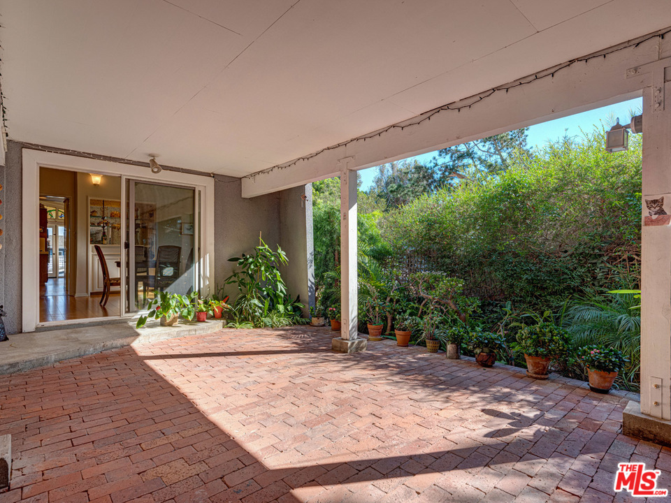 7553 Trask Avenue Playa del Rey, CA 90293 - Photo 12 of 24 a view of a patio with table and chairs in front of a white house