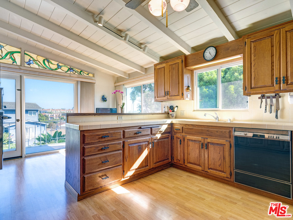 7553 Trask Avenue Playa del Rey, CA 90293 - Photo 6 of 24 a kitchen with stainless steel appliances granite countertop a sink a stove cabinets and wooden floor