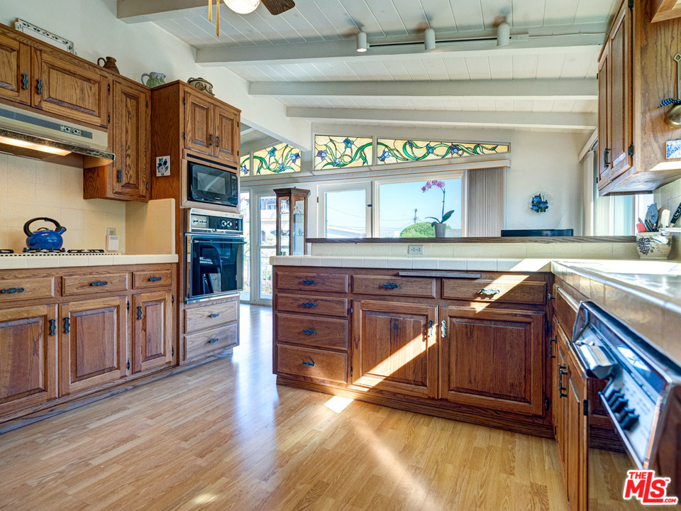 7553 Trask Avenue Playa del Rey, CA 90293 - Photo 7 of 24 a kitchen with stainless steel appliances granite countertop a stove and cabinets
