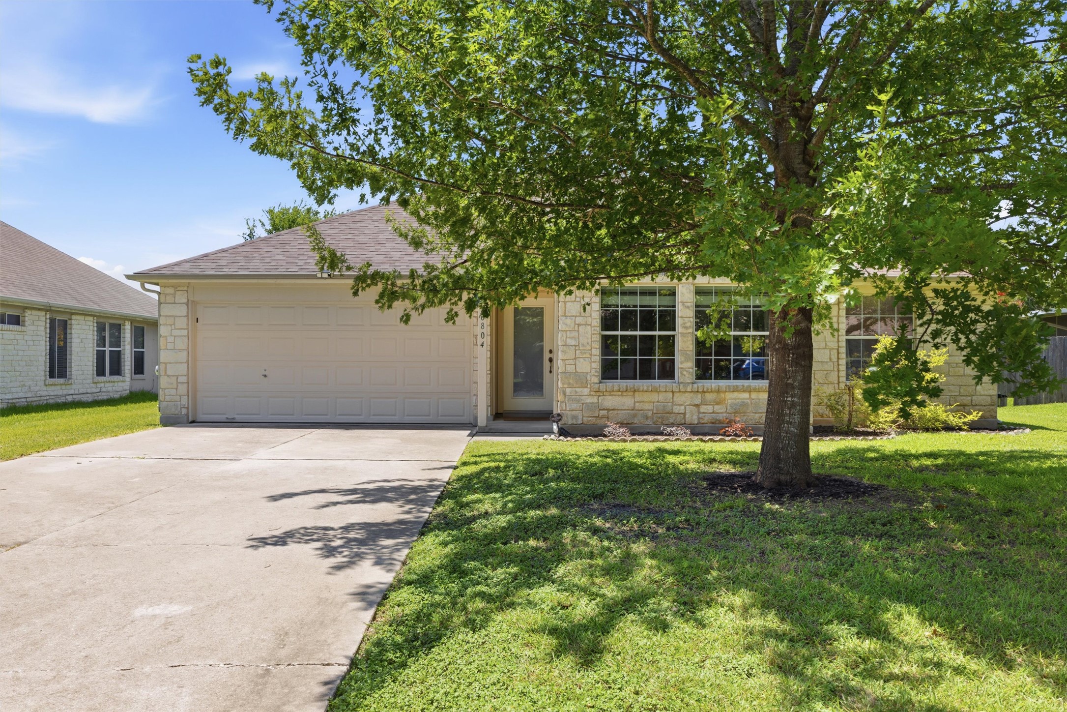 16804 Gravesend Road Pflugerville, TX 78660 - Photo 1 of 1 A well-maintained facade featuring stone, a front entry attached garage, and a lush front yard.