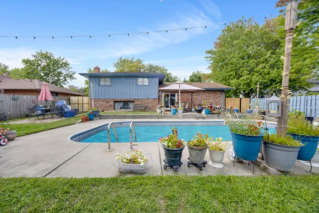 a view of a house with pool and chairs