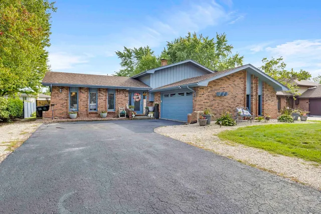 a view of a house with a yard and potted plants