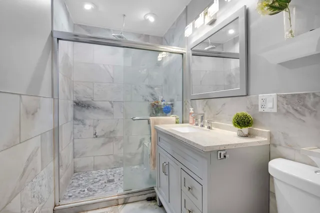 a bathroom with a sink a toilet and shower