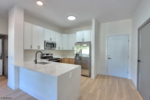 a kitchen with granite countertop a sink stove and refrigerator