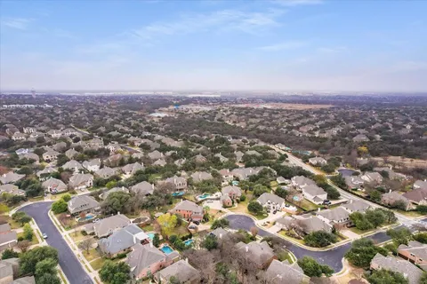 an aerial view of a house with swimming pool and a yard