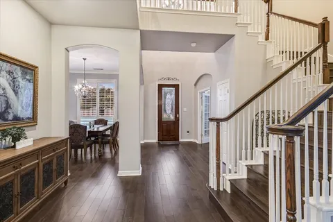 a view of a hallway with wooden floor and staircase