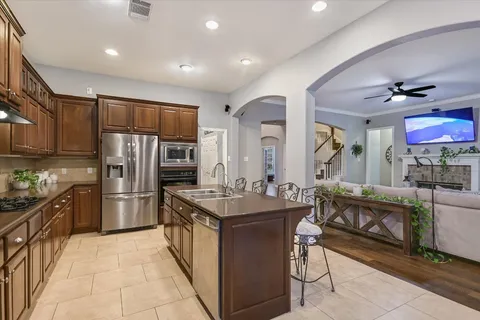 a kitchen with stainless steel appliances granite countertop a sink stove and refrigerator