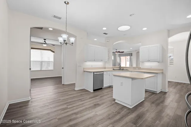 a large kitchen with cabinets wooden floor and stainless steel appliances