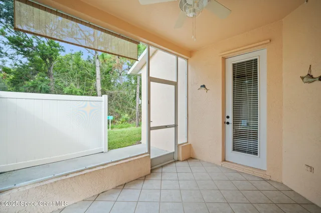 a view of a backyard with table and chairs with potted plants and large tree