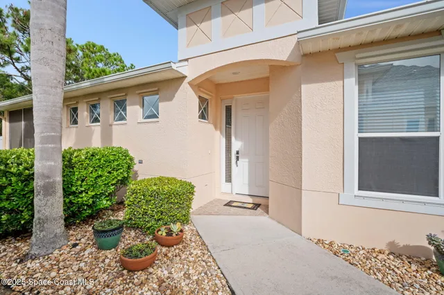 a view of a porch with chairs and potted plants