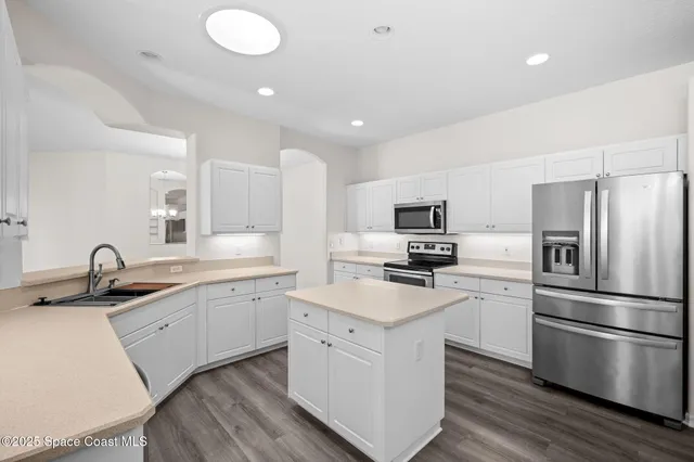 a kitchen with a sink stainless steel appliances and cabinets