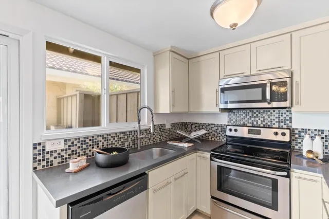 a kitchen with granite countertop a sink stainless steel appliances and cabinets