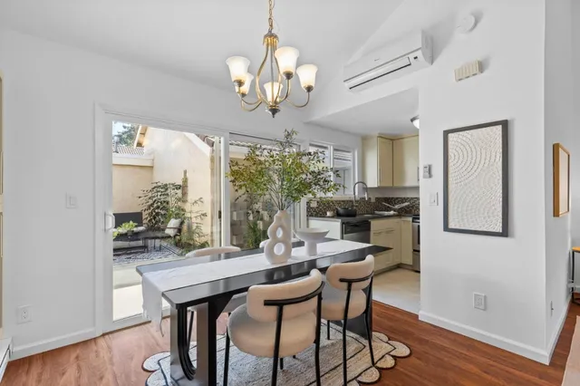 a view of a dining room with furniture a chandelier and wooden floor
