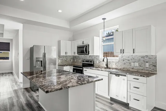 a kitchen with stainless steel appliances granite countertop a sink stove and refrigerator
