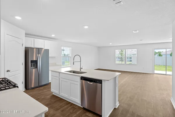a kitchen with stainless steel appliances granite countertop a sink a stove a refrigerator and island