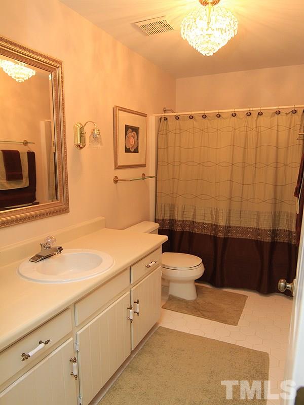 1530 Edgeside Court Raleigh, NC 27609 - Photo 11 of 20 a bathroom with a granite countertop sink toilet a mirror and shower curtain