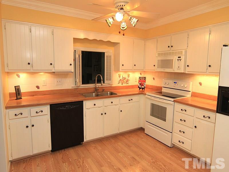 1530 Edgeside Court Raleigh, NC 27609 - Photo 3 of 20 a kitchen with cabinets stainless steel appliances a sink and wooden floor