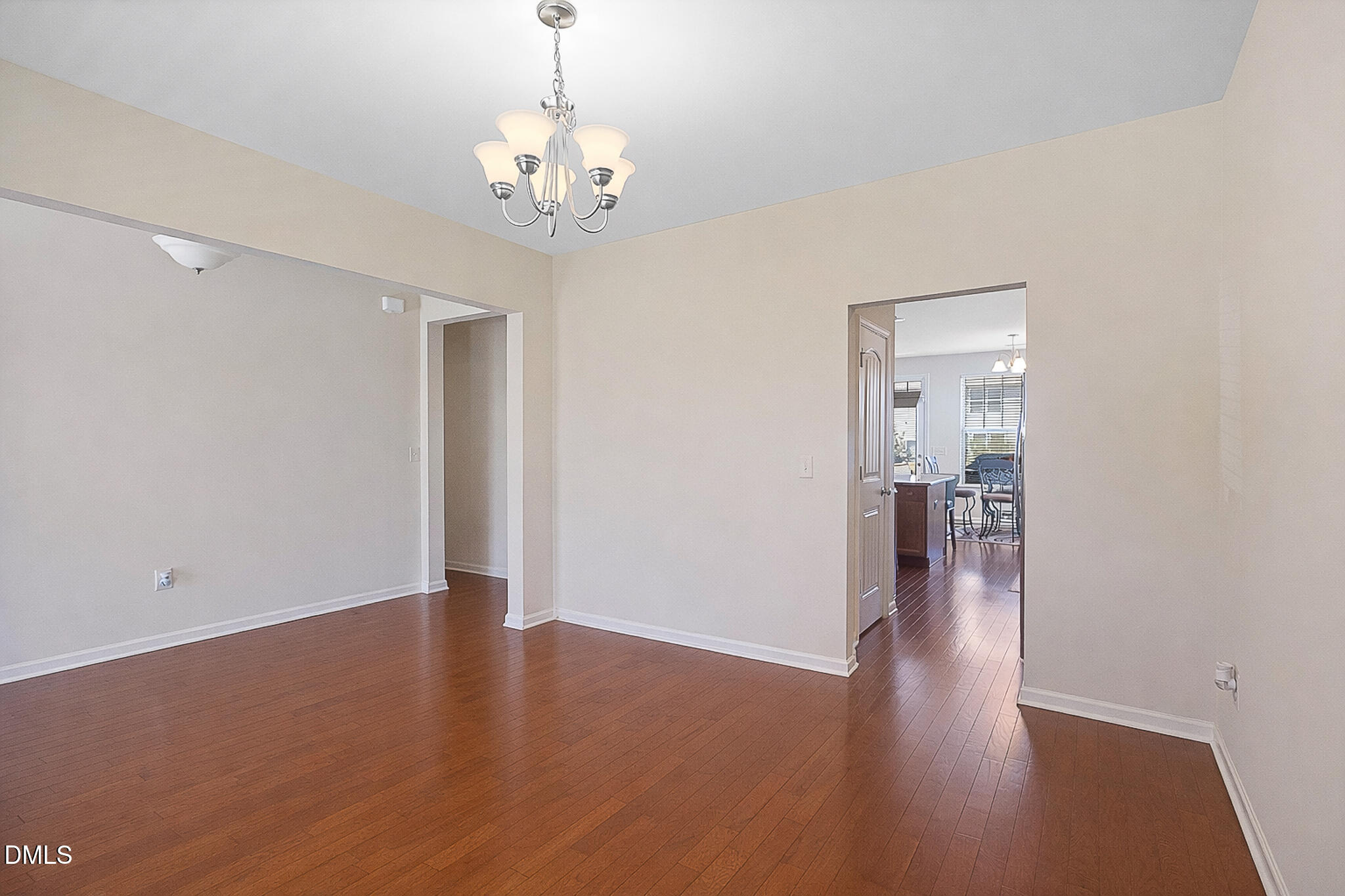 4249 Saubranch Hill Street Raleigh, NC 27616 - Photo 8 of 31 a view of a hallway with wooden floor and a chandelier
