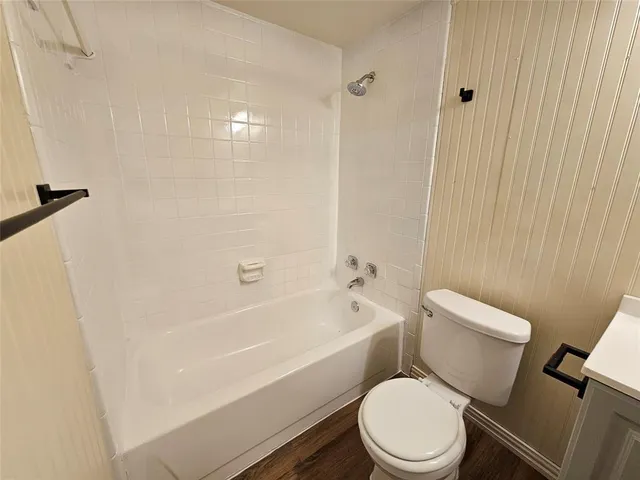 a white toilet and tub sitting next to a white cabinet