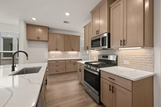 a view of a kitchen with a sink and a stove top oven